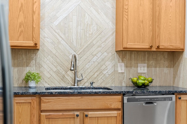 kitchen with dark stone countertops, dishwasher, light brown cabinets, and sink