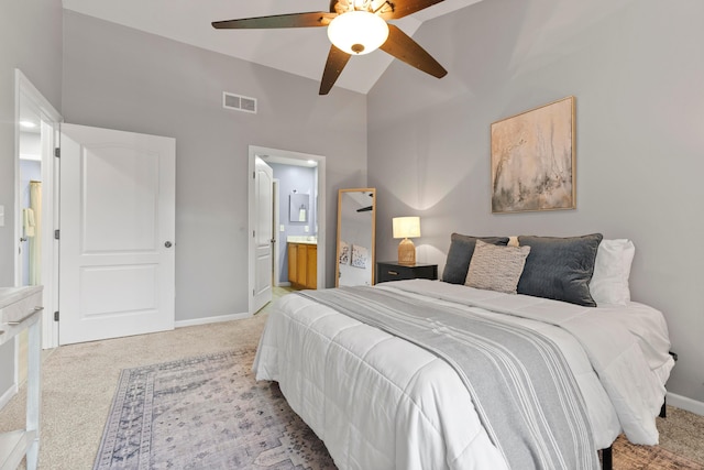 carpeted bedroom with ensuite bathroom, ceiling fan, and lofted ceiling