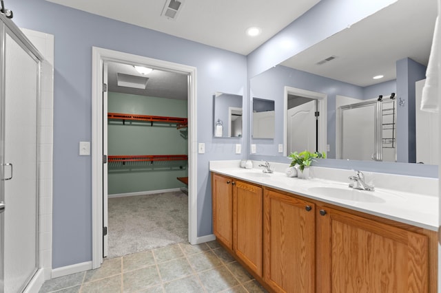 bathroom featuring tile patterned flooring, vanity, and walk in shower