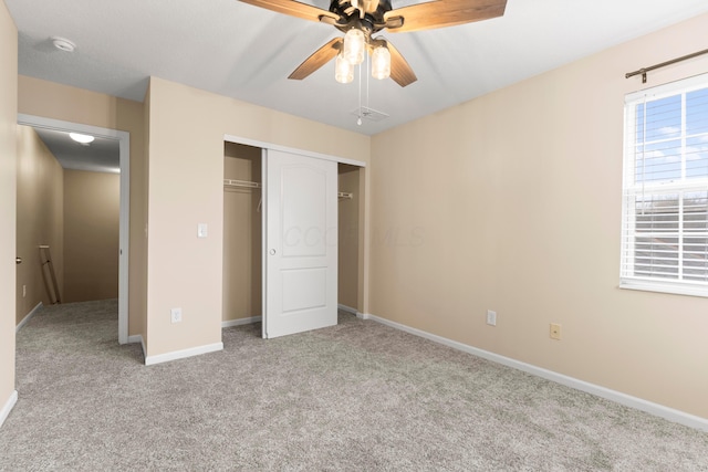 unfurnished bedroom featuring ceiling fan, a closet, and light carpet