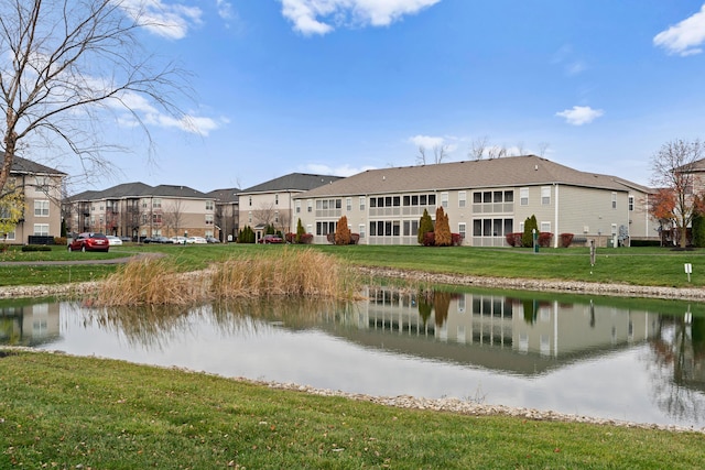 rear view of property featuring a lawn and a water view