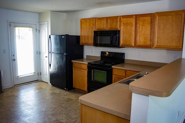 kitchen with kitchen peninsula, a textured ceiling, sink, and black appliances