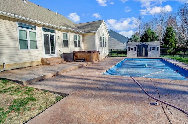 view of swimming pool with a shed, a patio area, and a hot tub