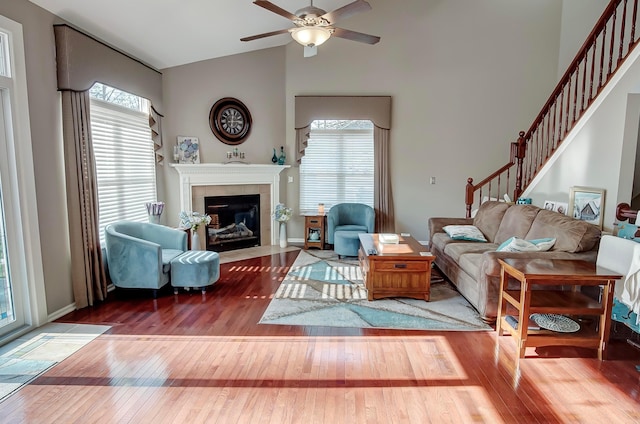 living room with hardwood / wood-style floors, a fireplace, ceiling fan, and vaulted ceiling