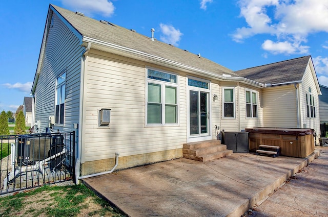 back of house featuring a hot tub and a patio area