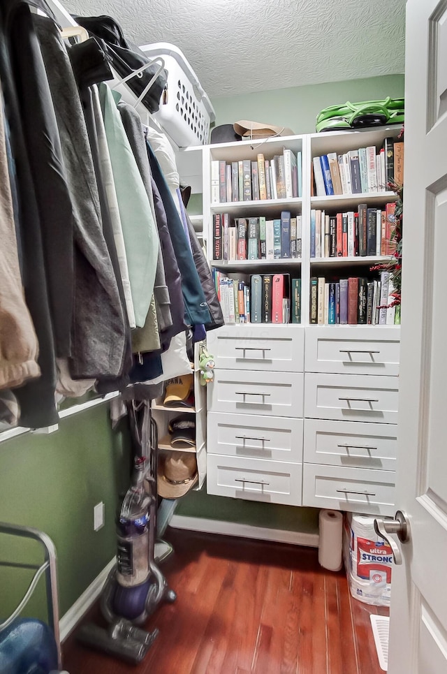 spacious closet with dark hardwood / wood-style flooring