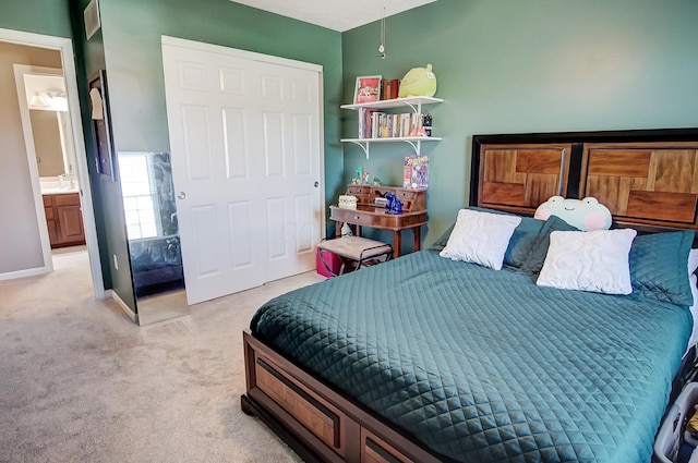 bedroom with ensuite bath and light colored carpet