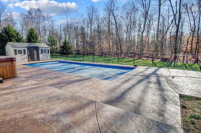 view of pool featuring a yard, an outbuilding, and a patio area