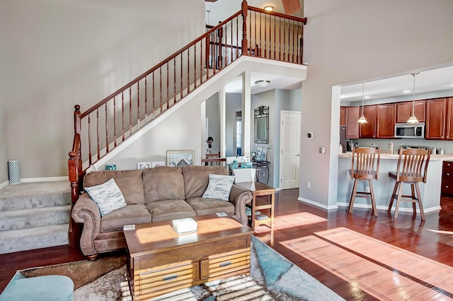 living room featuring dark hardwood / wood-style flooring and a towering ceiling