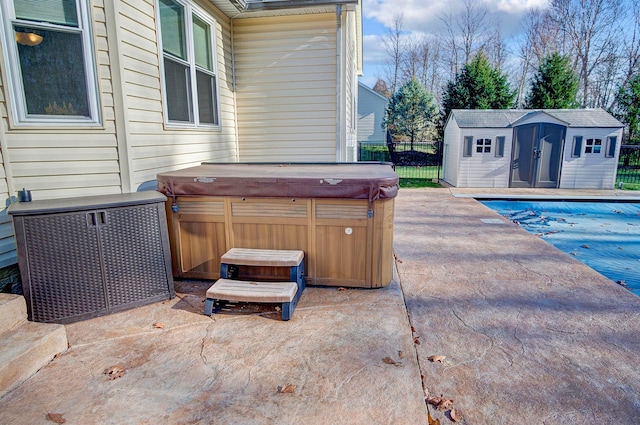 view of patio with a storage unit and a pool with hot tub