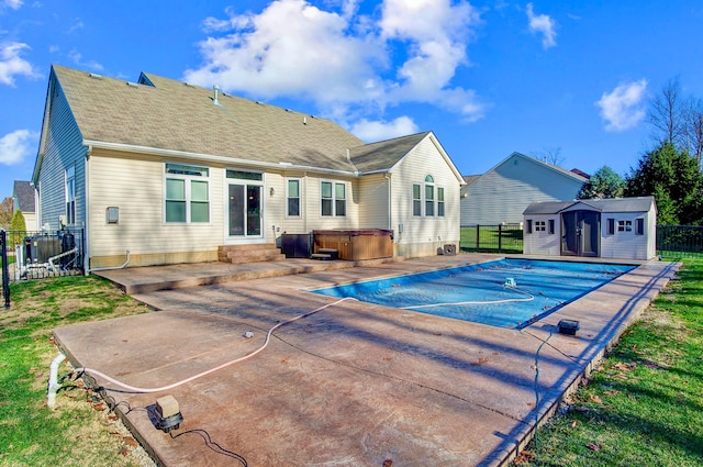 view of pool featuring a hot tub, a patio, and a storage shed