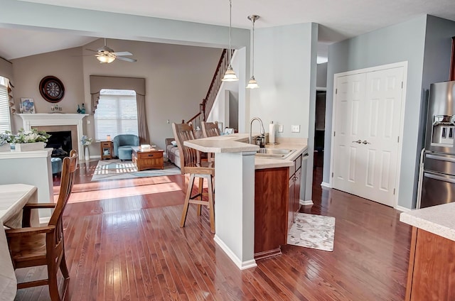 kitchen with appliances with stainless steel finishes, dark hardwood / wood-style floors, sink, and hanging light fixtures