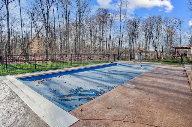 view of swimming pool featuring a playground and a yard