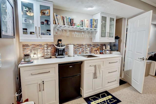 kitchen with white cabinets, sink, and backsplash