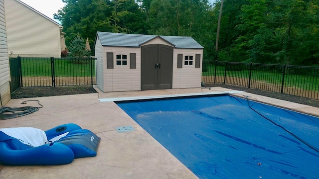 view of swimming pool featuring a patio and a shed