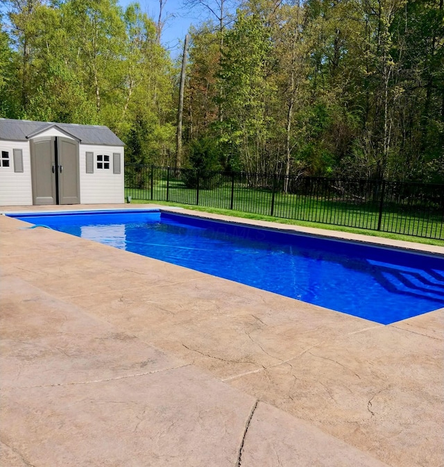 view of pool with an outbuilding, a yard, and a patio