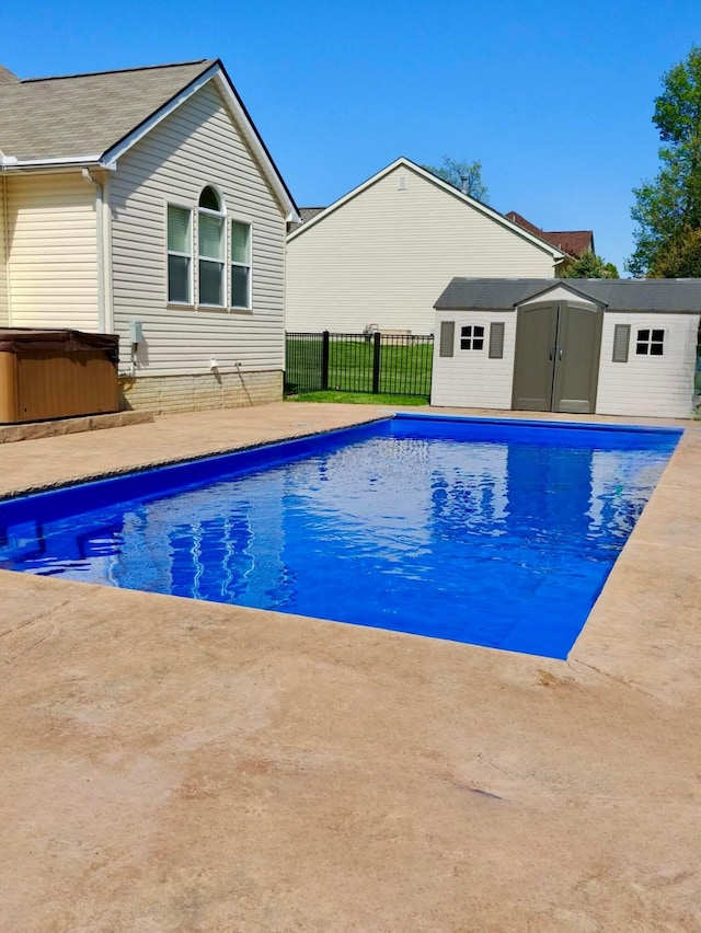 view of pool featuring an outdoor structure, a patio, and a hot tub