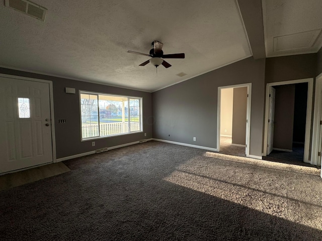 foyer entrance featuring vaulted ceiling with beams, ceiling fan, dark carpet, and a textured ceiling