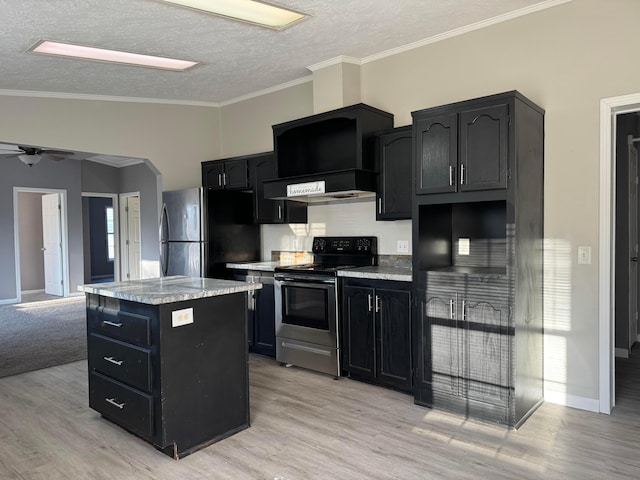 kitchen with ceiling fan, a kitchen island, light wood-type flooring, and stainless steel appliances