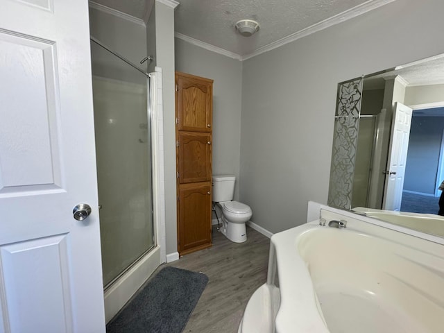 bathroom with a textured ceiling, crown molding, independent shower and bath, hardwood / wood-style floors, and toilet