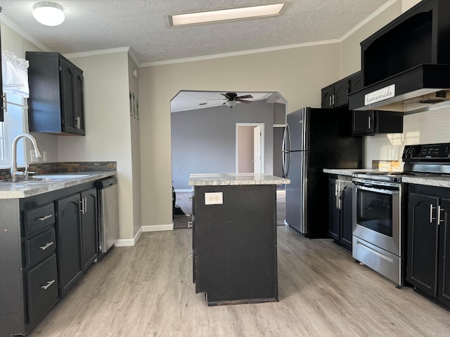 kitchen featuring ceiling fan, a kitchen island, light wood-type flooring, and appliances with stainless steel finishes