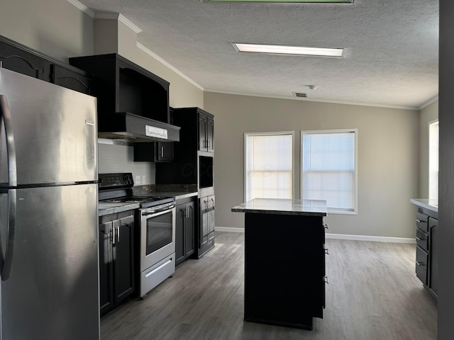 kitchen featuring ornamental molding, a center island, stainless steel appliances, and wood-type flooring