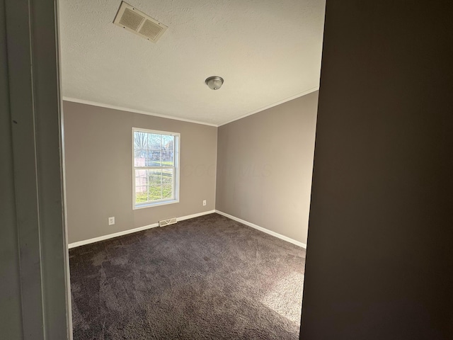 carpeted empty room featuring ornamental molding and a textured ceiling