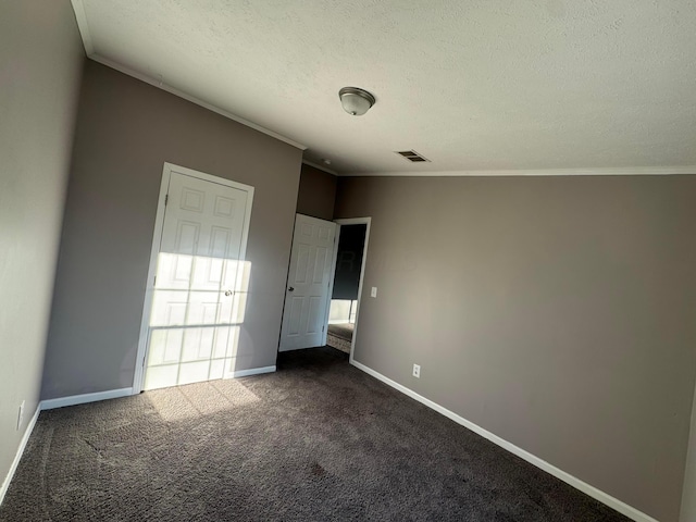 unfurnished bedroom featuring ornamental molding, a textured ceiling, and dark colored carpet