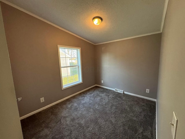 carpeted spare room featuring a textured ceiling, vaulted ceiling, and ornamental molding