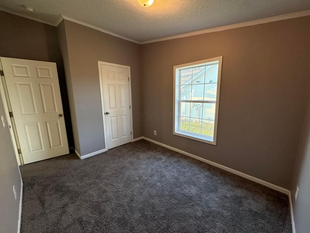 unfurnished bedroom featuring crown molding, dark carpet, and a textured ceiling