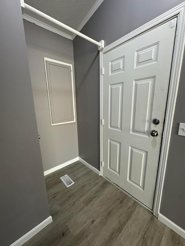 interior space with dark hardwood / wood-style floors and crown molding