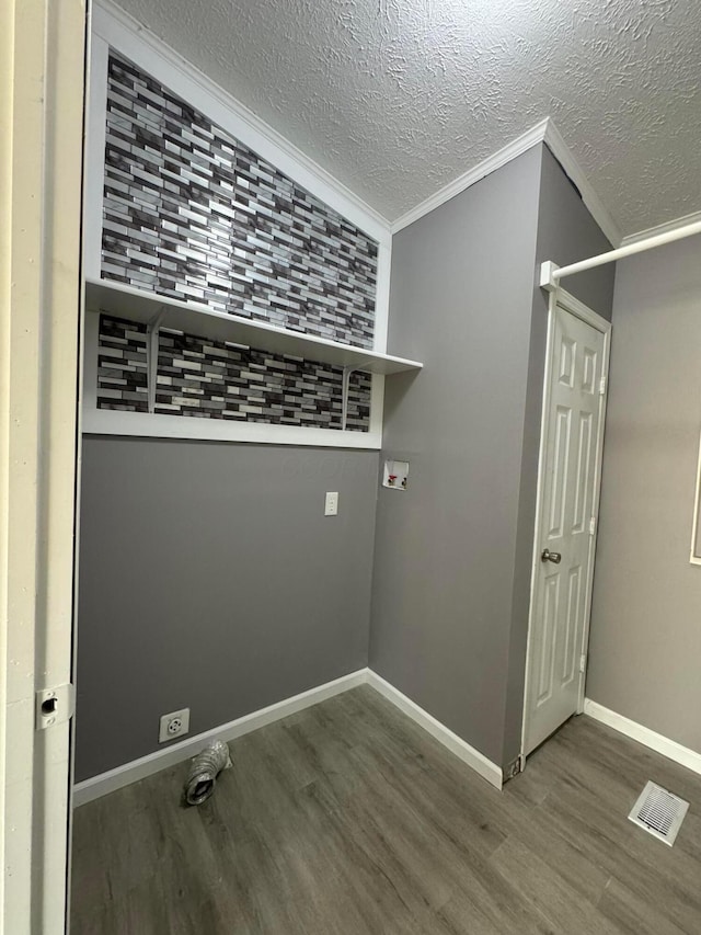 laundry room with hookup for a washing machine, wood-type flooring, a textured ceiling, and ornamental molding