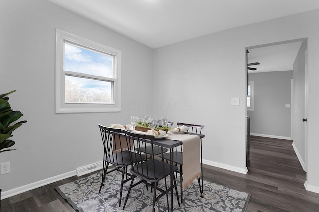 dining space featuring ceiling fan and dark wood-type flooring