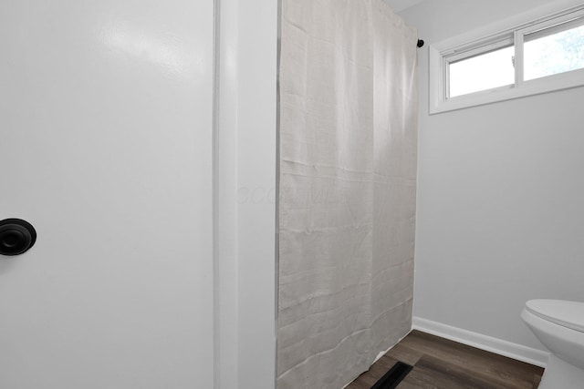 bathroom with hardwood / wood-style flooring and toilet