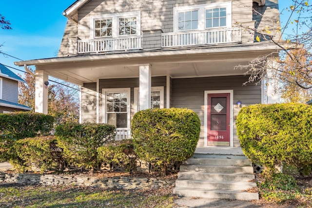 view of front of property featuring a porch and a balcony