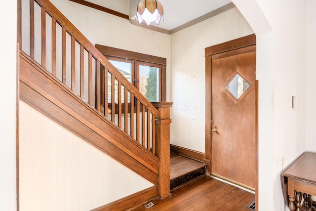 foyer entrance with crown molding and hardwood / wood-style floors