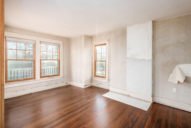 unfurnished room featuring dark hardwood / wood-style flooring and plenty of natural light