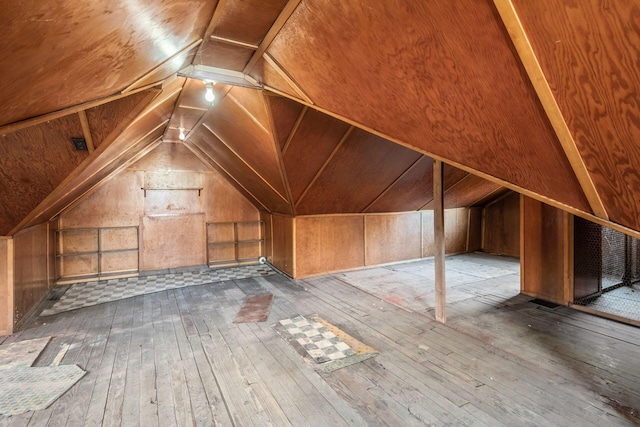 bonus room featuring built in features, lofted ceiling, and hardwood / wood-style flooring