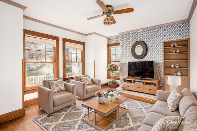 living room with light hardwood / wood-style flooring, a wealth of natural light, crown molding, and ceiling fan