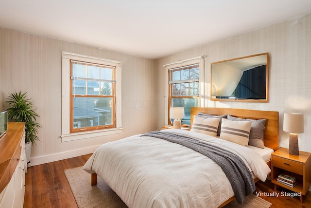 bedroom with dark hardwood / wood-style flooring and multiple windows