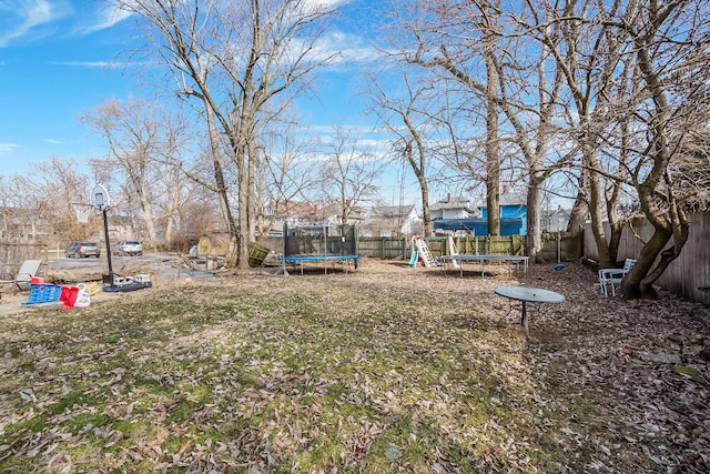 view of yard with a playground and a trampoline