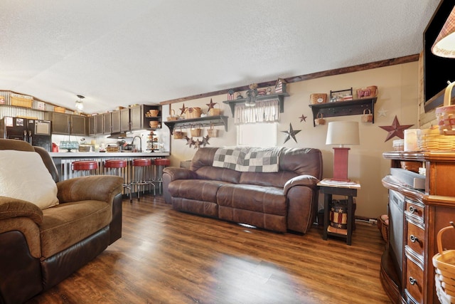 living room with a textured ceiling, dark hardwood / wood-style flooring, vaulted ceiling, and ornamental molding