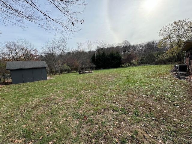 view of yard with central AC and an outbuilding