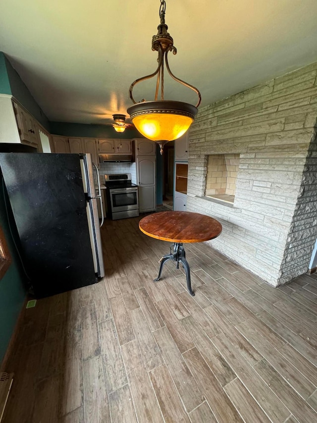 kitchen with stainless steel range, refrigerator, and hardwood / wood-style flooring