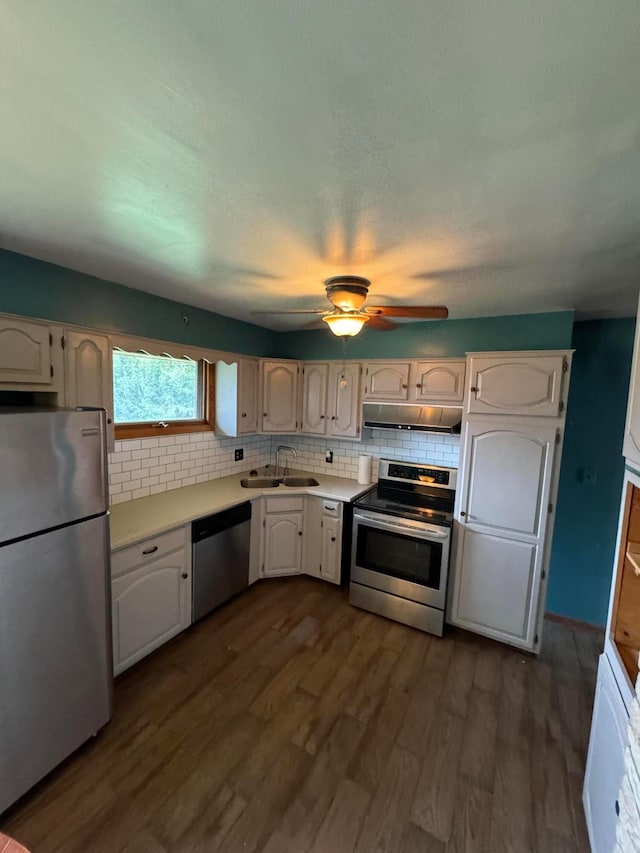 kitchen with dark hardwood / wood-style flooring, backsplash, stainless steel appliances, sink, and white cabinets