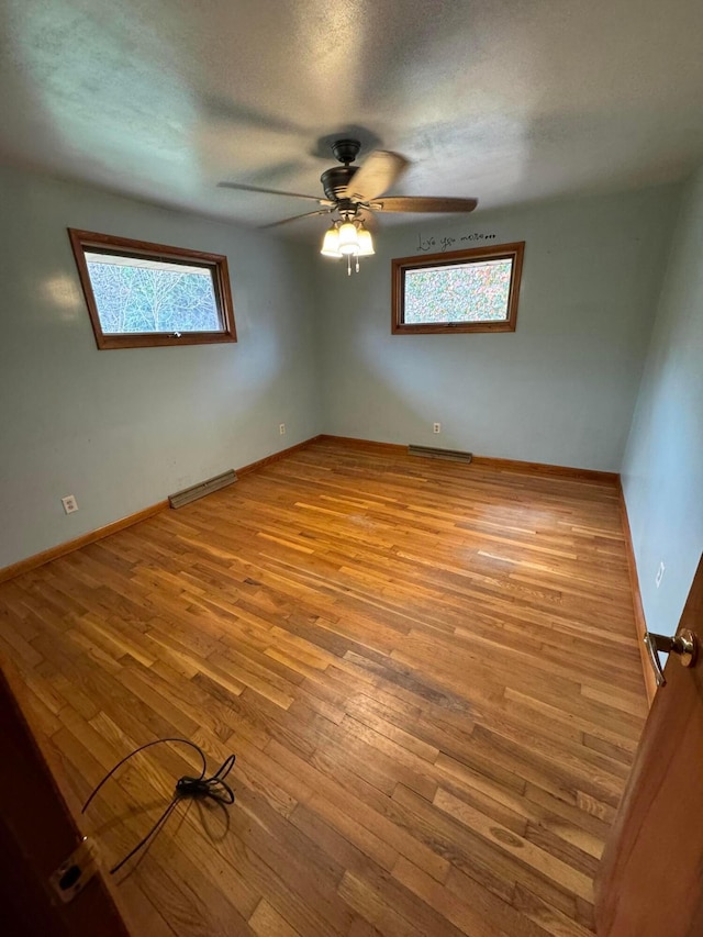 spare room with ceiling fan, light hardwood / wood-style flooring, and a textured ceiling