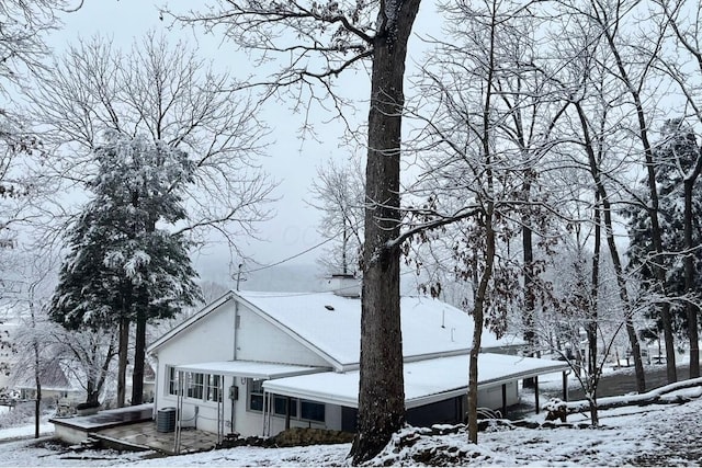 snow covered property featuring central AC unit