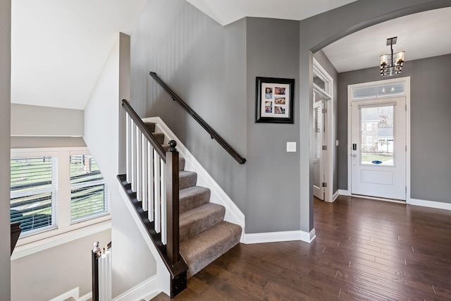 foyer featuring dark wood-type flooring and an inviting chandelier