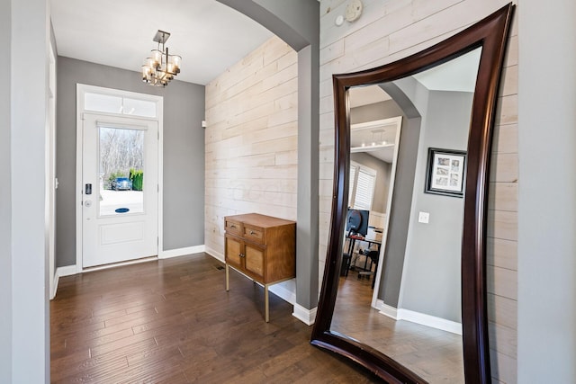 foyer featuring dark hardwood / wood-style flooring, plenty of natural light, and a chandelier