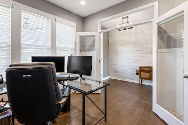 office space with wooden walls, dark hardwood / wood-style flooring, and a wealth of natural light